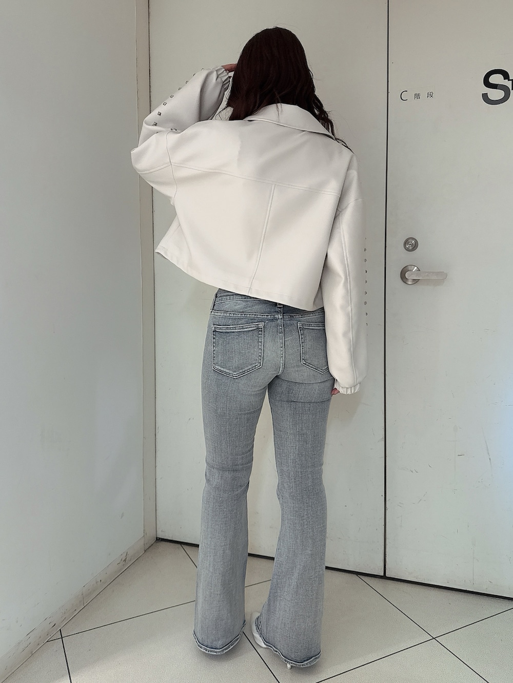 ホワイト系のパンプス、ブルー系のデニムパンツ、ホワイト系のキャミソールを着用したレディースの春コーディネートの3枚目の写真