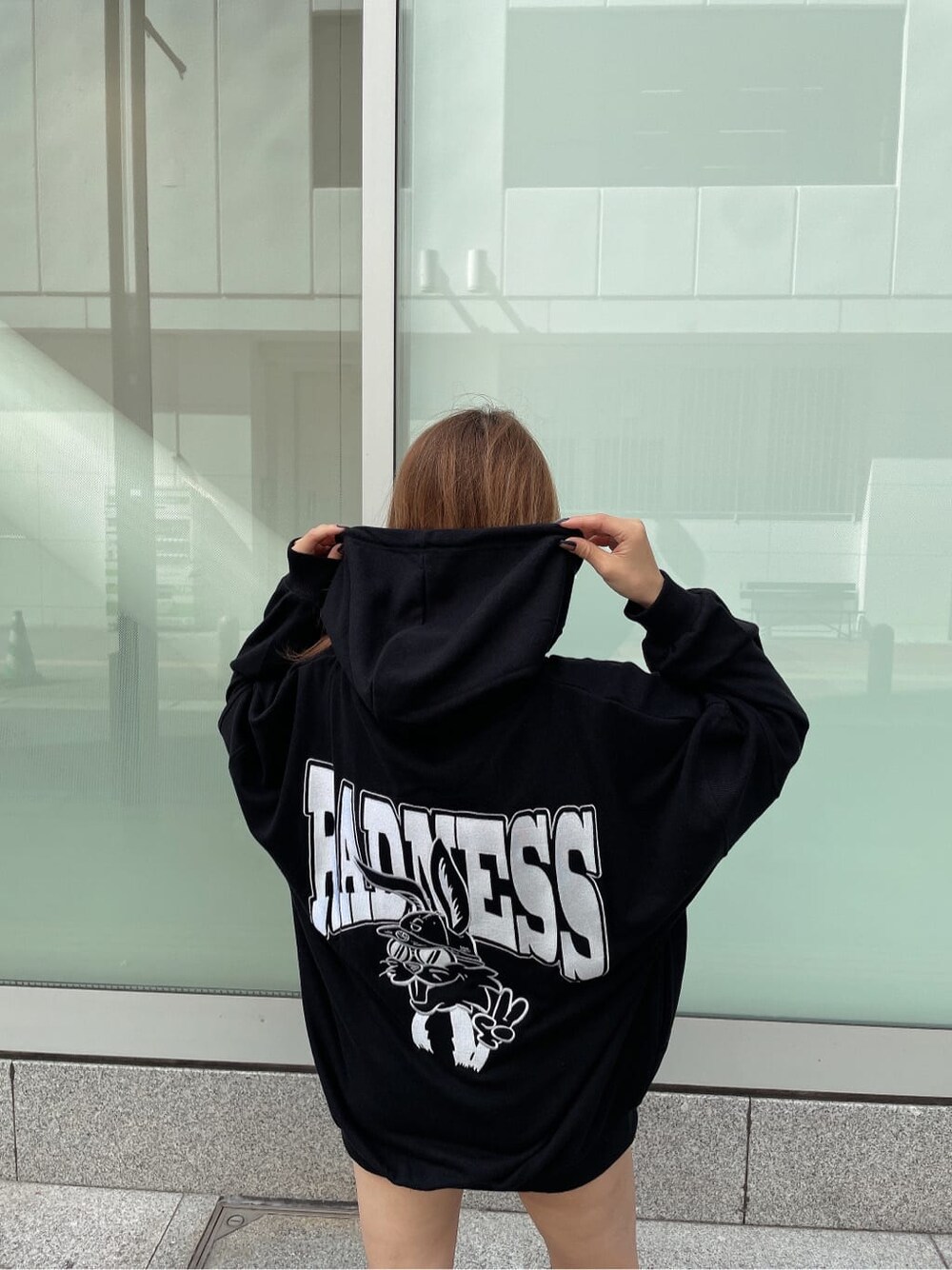 ブラック系のパーカー、ブラック系のデニムパンツ、ブラック系のブーツを着用したレディースの秋コーディネートの4枚目の写真