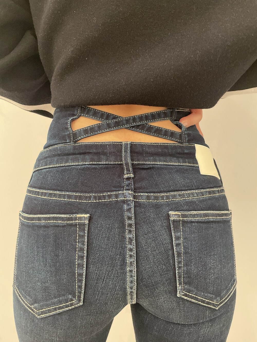 ブラック系のニット/セーター、ブルー系のデニムパンツ、ブラック系のパンプスを着用したレディースの冬コーディネートの6枚目の写真