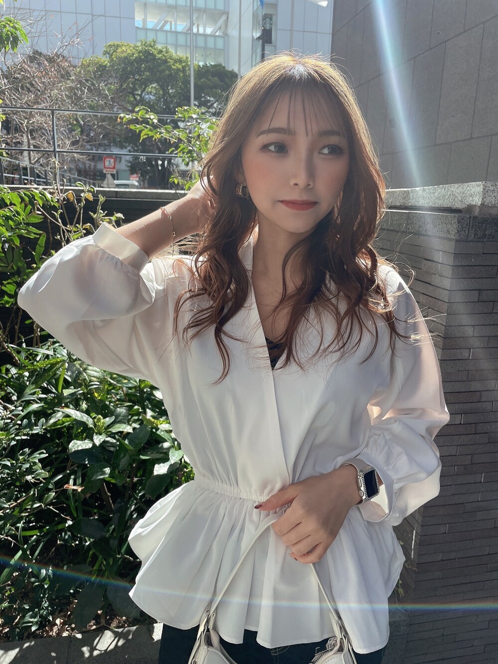 ブラック系のキャミソール、ホワイト系のシャツ/ブラウス、ホワイト系のハンドバッグを着用したレディースの冬コーディネートの3枚目の写真