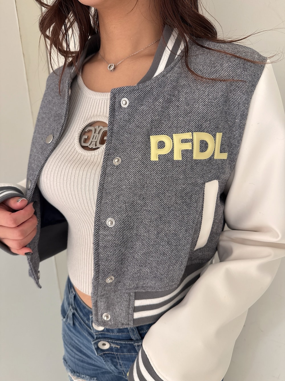 グレー系のニット/セーター、ブルー系のデニムパンツ、ホワイト系のパンプスを着用したレディースの冬コーディネートの7枚目の写真