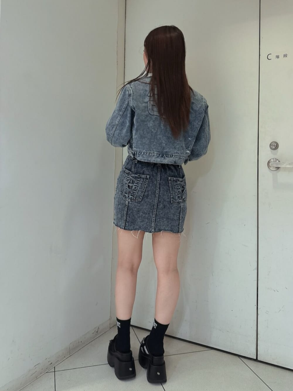 ブラック系のサンダル、ブルー系のワンピース、ブルー系のデニムジャケットを着用したレディースの春コーディネートの3枚目の写真