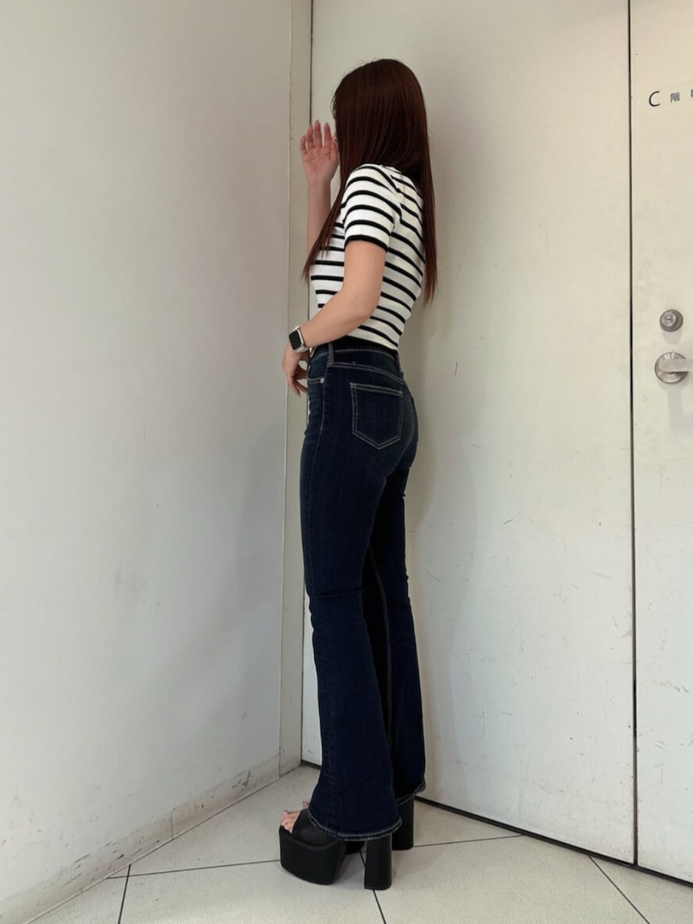 ブルー系のデニムパンツ、ブラック系のサンダル、その他のニット/セーターを着用したレディースの春コーディネートの2枚目の写真