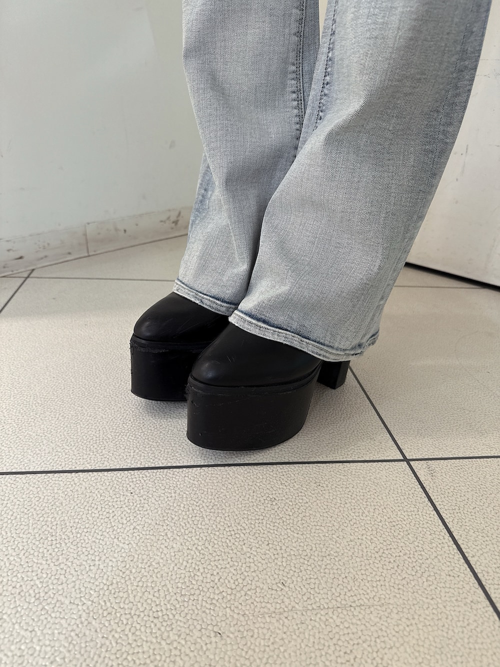 グレー系のニット/セーター、ブルー系のデニムパンツ、ブラック系のブーツを着用したレディースの秋コーディネートの8枚目の写真