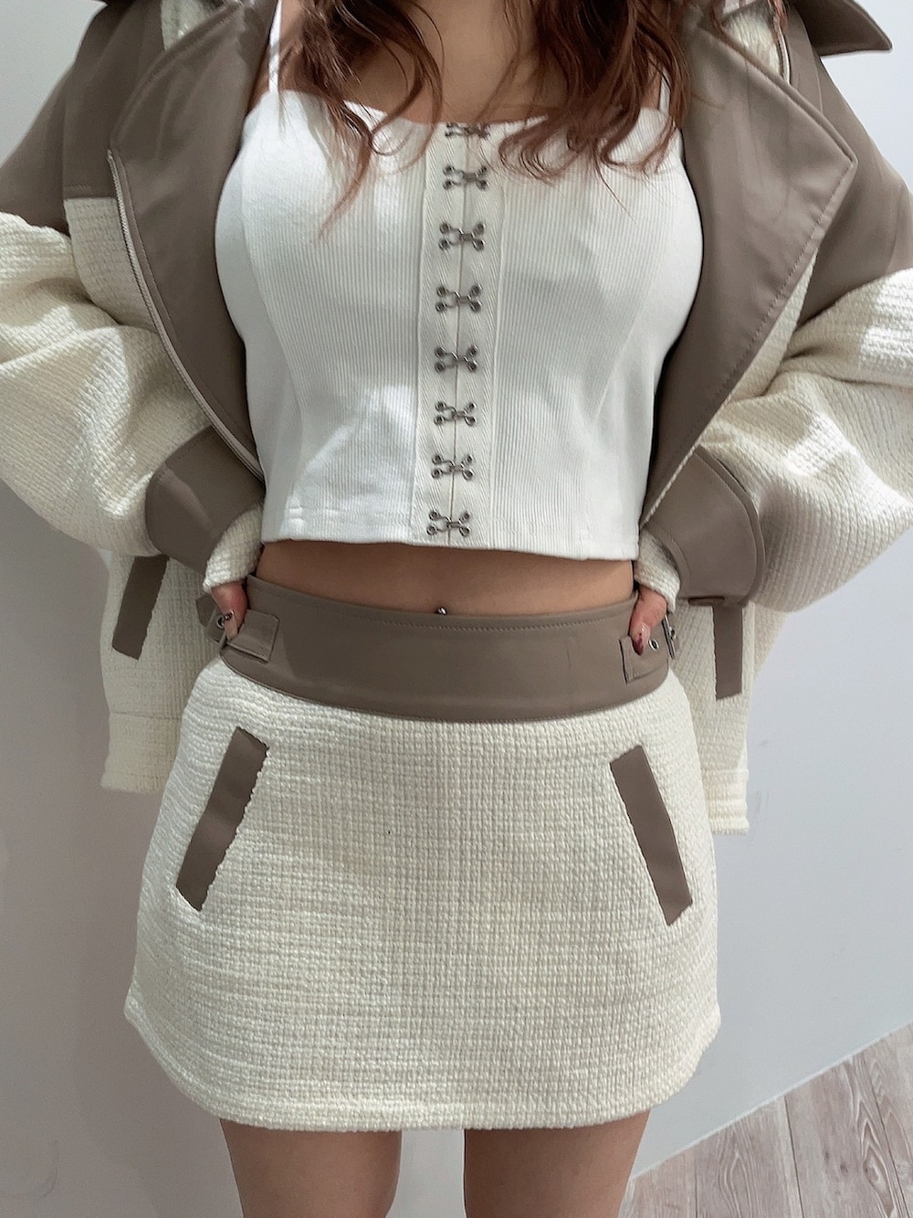 ホワイト系のキャミソール、ホワイト系のライダースジャケット、ホワイト系のスカートを着用したレディースの春コーディネートの7枚目の写真