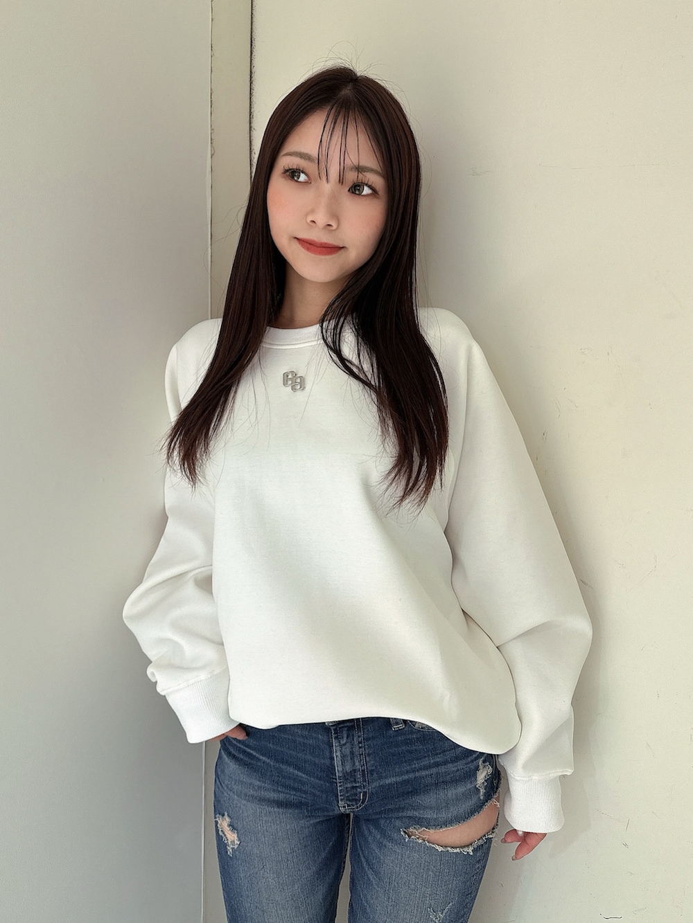 ブルー系のデニムパンツ、ブラック系のブーツ、ホワイト系のスウェットを着用したレディースの冬コーディネートの4枚目の写真