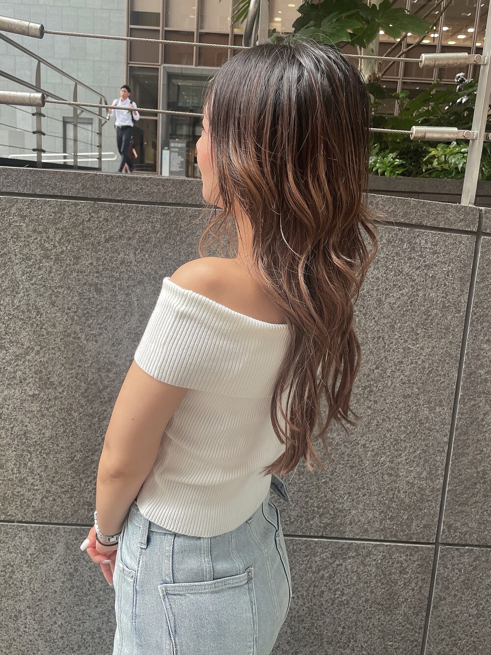 ブルー系のデニムスカート、ホワイト系のサンダル、ホワイト系のニット/セーターを着用したレディースの夏コーディネートの5枚目の写真