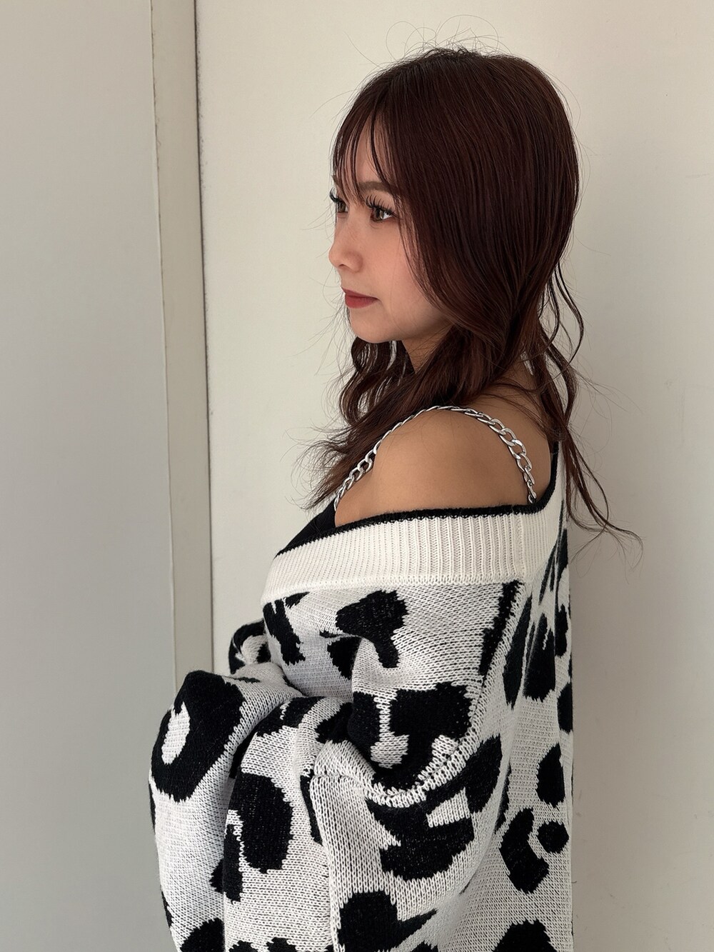 ホワイト系のカーディガン/ボレロ、ブラック系のキャミソール、ブラック系のデニムパンツを着用したレディースの春コーディネートの5枚目の写真