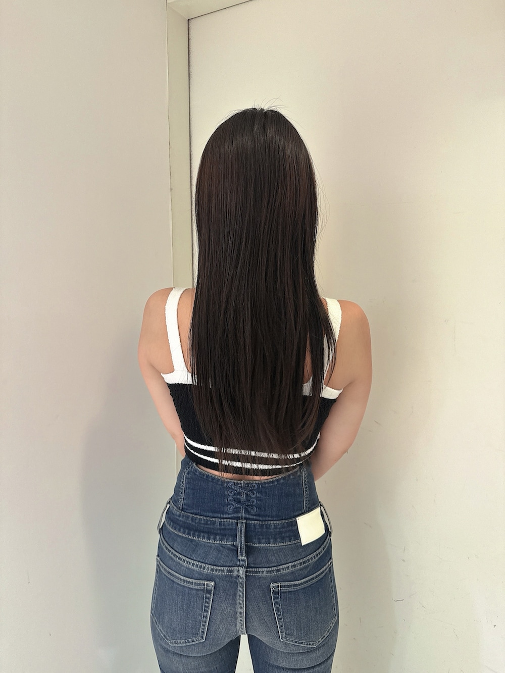 ブルー系のデニムパンツ、ブラック系のキャミソール、ブラック系のサンダルを着用したレディースの春コーディネートの6枚目の写真