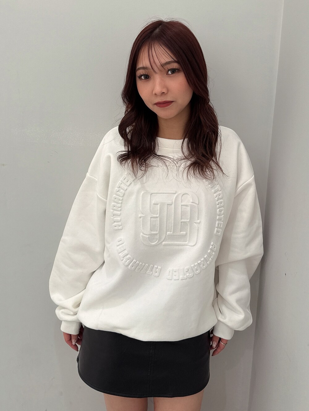 ブラック系のスカート、ブラック系のブーツ、ホワイト系のスウェットを着用したレディースの冬コーディネートの4枚目の写真