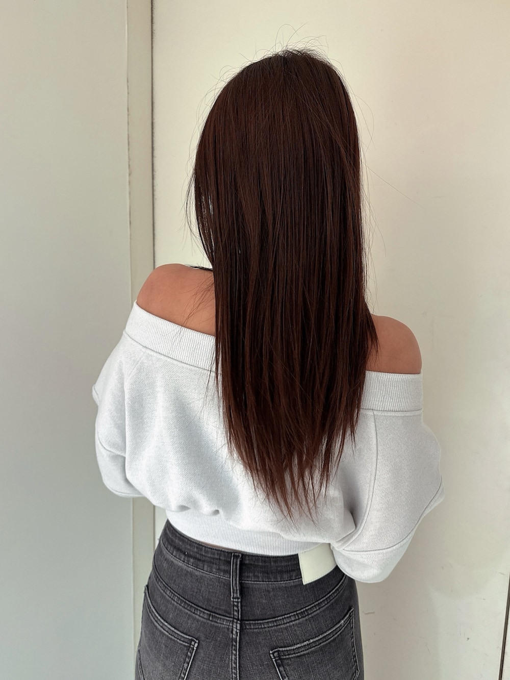 ブラック系のデニムパンツ、ブラック系のブーツ、ホワイト系のTシャツ/カットソーを着用したレディースの冬コーディネートの6枚目の写真