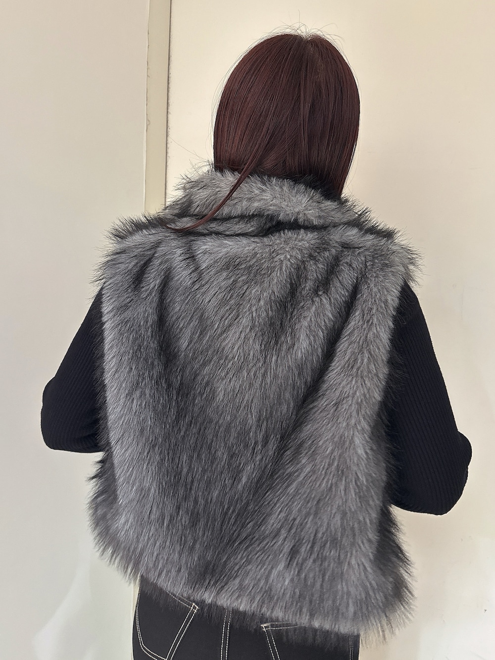 ブラック系のニット/セーター、ブラック系のデニムパンツ、ブラック系のブーツを着用したレディースの秋コーディネートの6枚目の写真