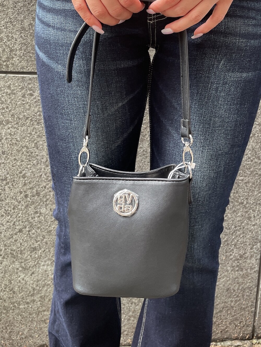 レッド系のキャミソール、ブルー系のデニムパンツ、ブラック系のショルダーバッグを着用したレディースの夏コーディネートの9枚目の写真