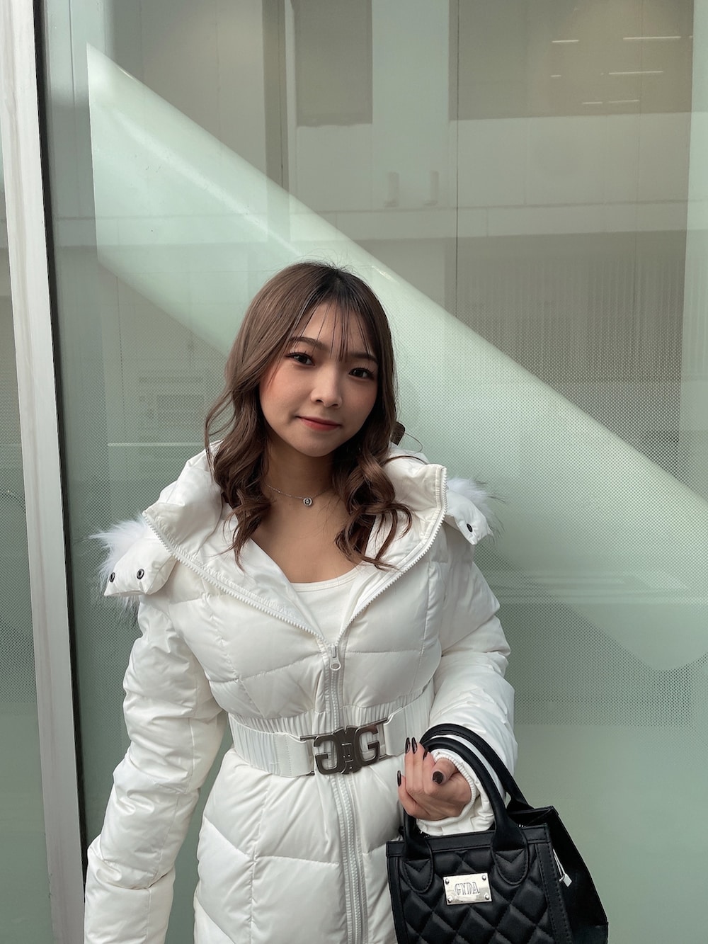 ホワイト系のTシャツ/カットソー、ブラック系のハンドバッグ、ブラック系のブーツを着用したレディースの秋コーディネートの5枚目の写真