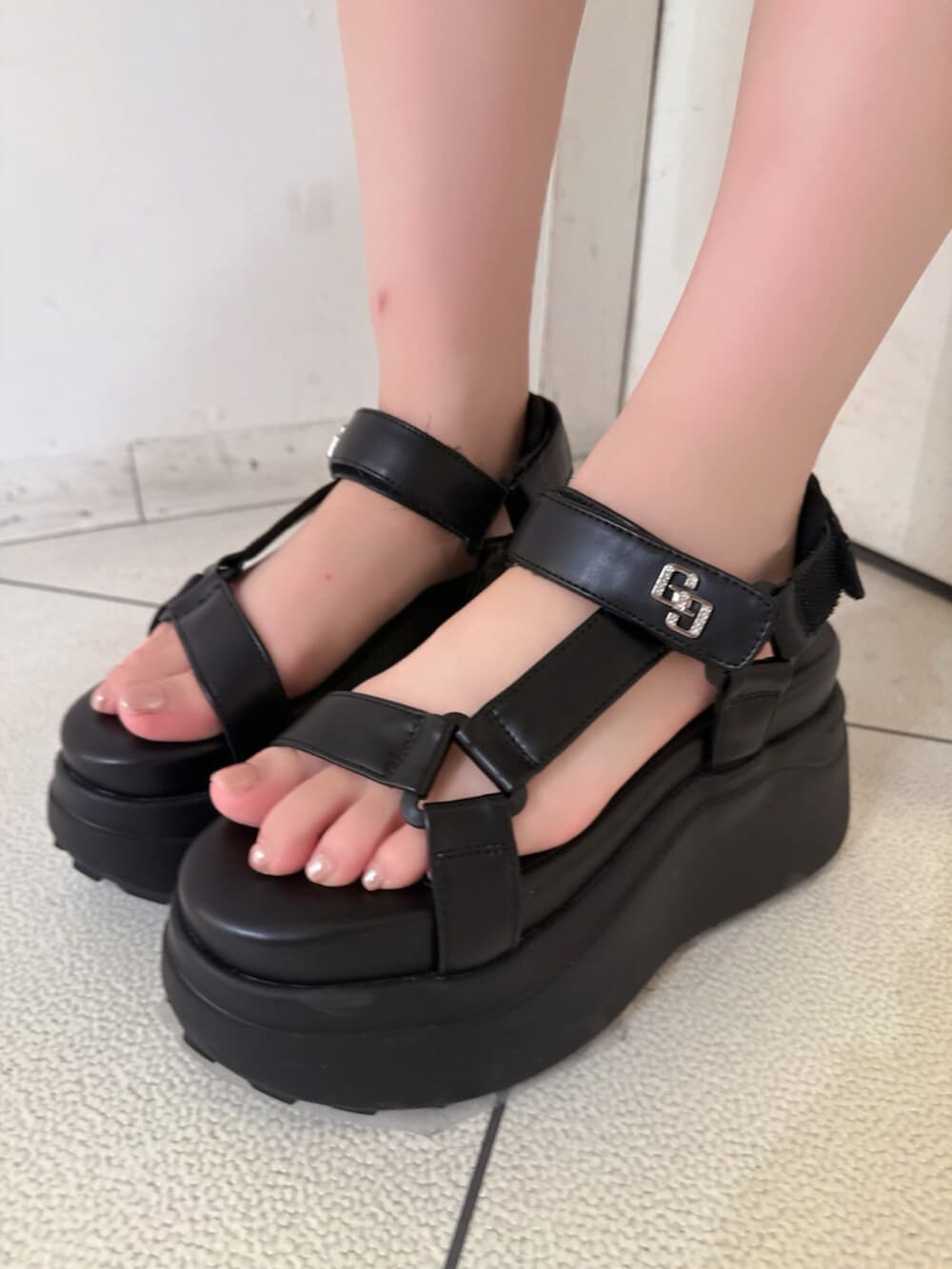 ブラック系のサンダル、ブラック系のデニムパンツ、ホワイト系のチューブトップを着用したレディースの夏コーディネートの9枚目の写真
