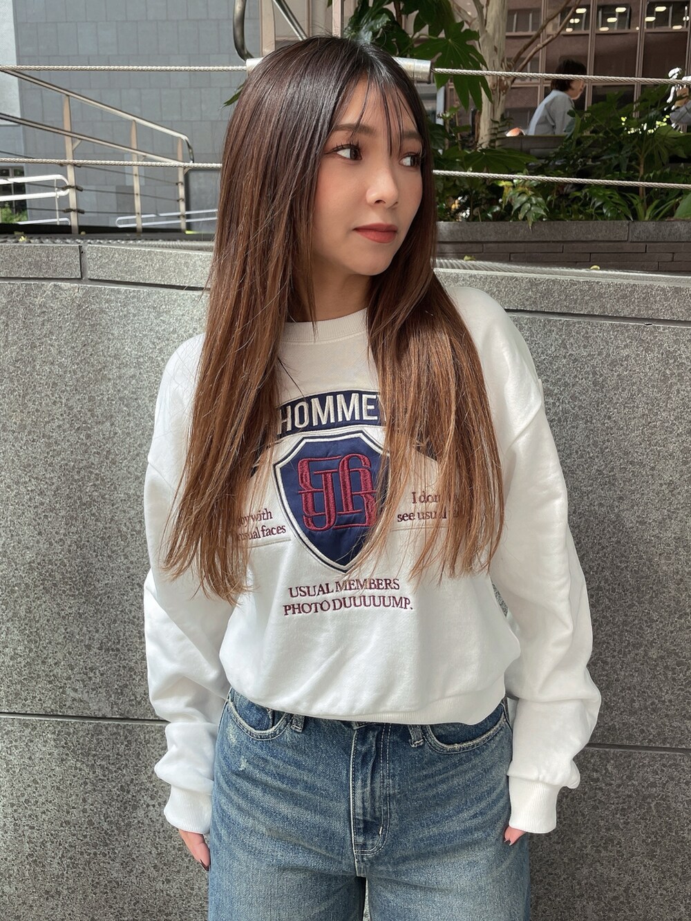 ブラック系のブーツ、ブラック系のデニムパンツ、ホワイト系のスウェットを着用したレディースの秋コーディネートの4枚目の写真