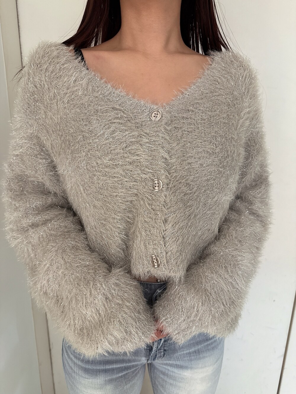 ブルー系のデニムパンツ、ホワイト系のパンプス、ベージュ系のカーディガン/ボレロを着用したレディースの秋コーディネートの7枚目の写真