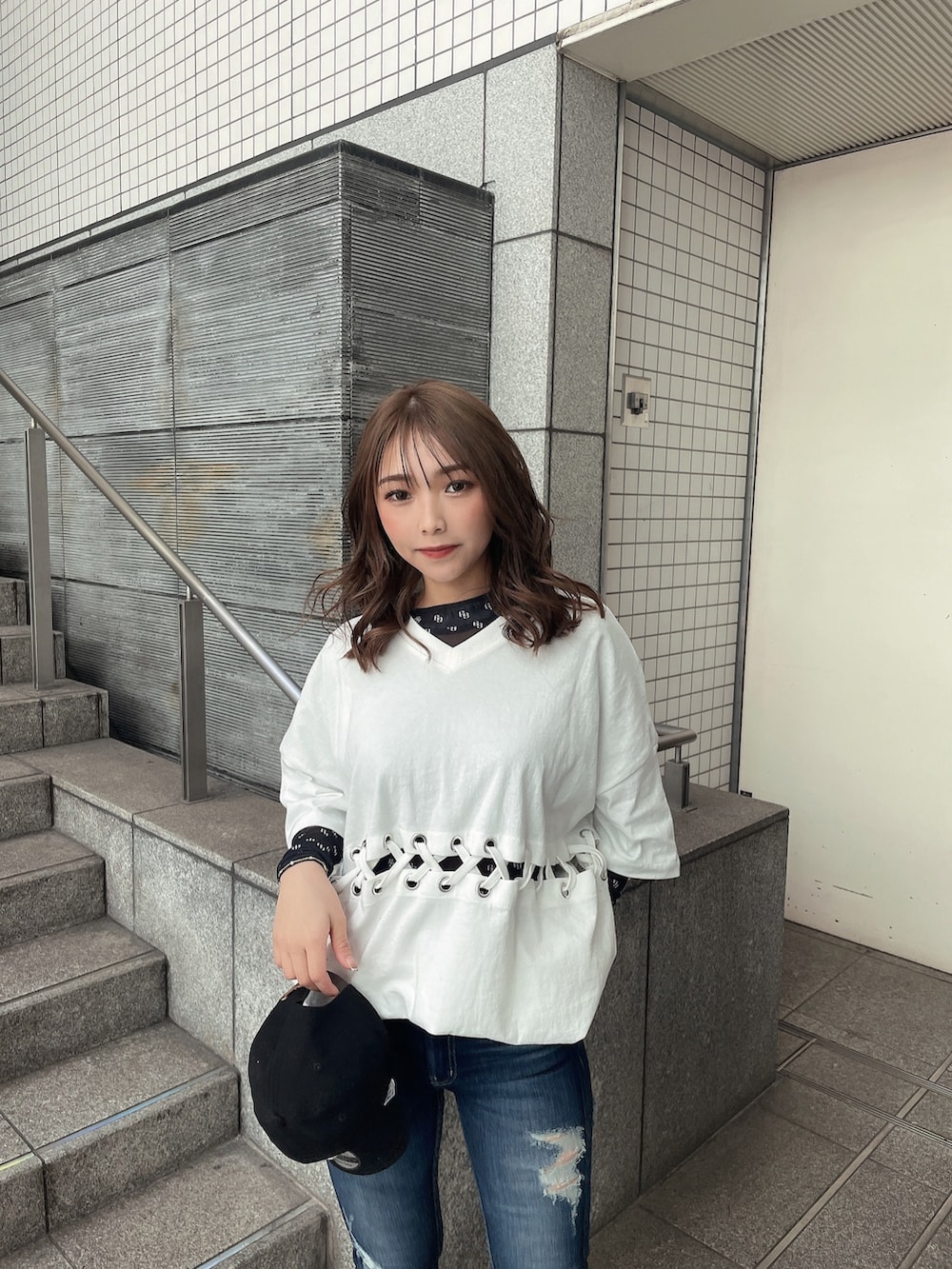 ブルー系のデニムパンツ、ブラック系のパンプス、ブラック系のTシャツ/カットソーを着用したレディースの春コーディネートの3枚目の写真