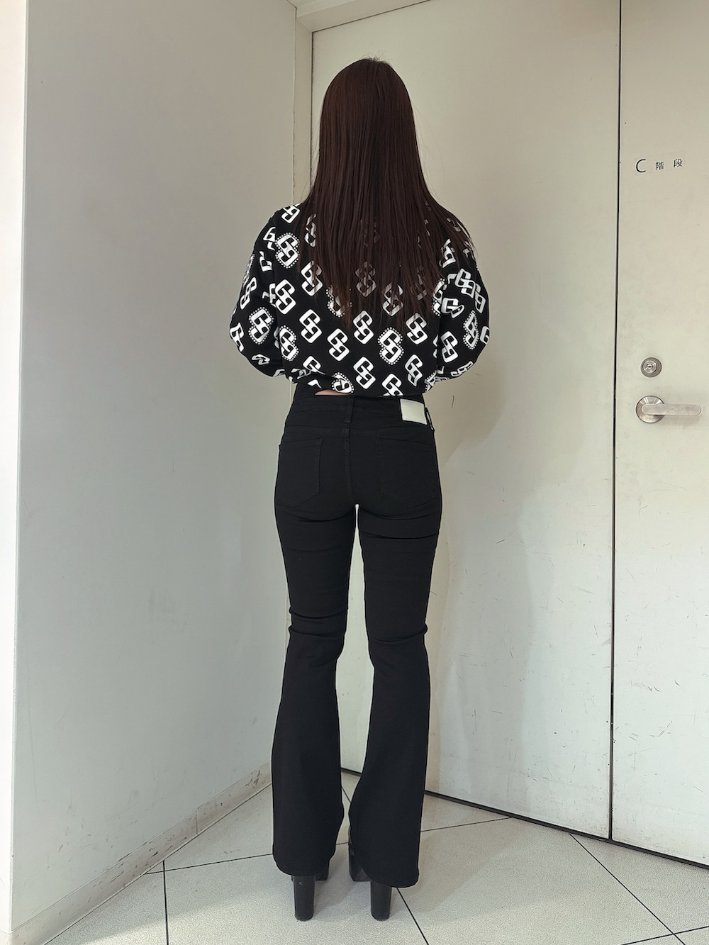 ブラック系のデニムパンツ、ブラック系のブーツ、ブラック系のスウェットを着用したレディースの冬コーディネートの3枚目の写真