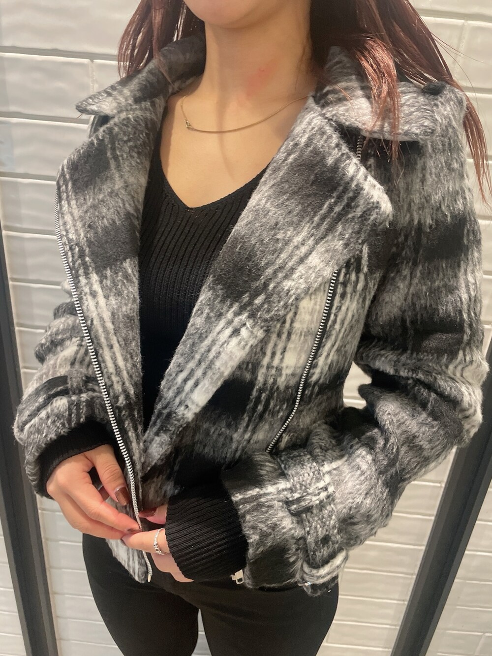 その他のライダースジャケット、ブラック系のニット/セーター、ブラック系のデニムパンツを着用したレディースの秋コーディネートの7枚目の写真