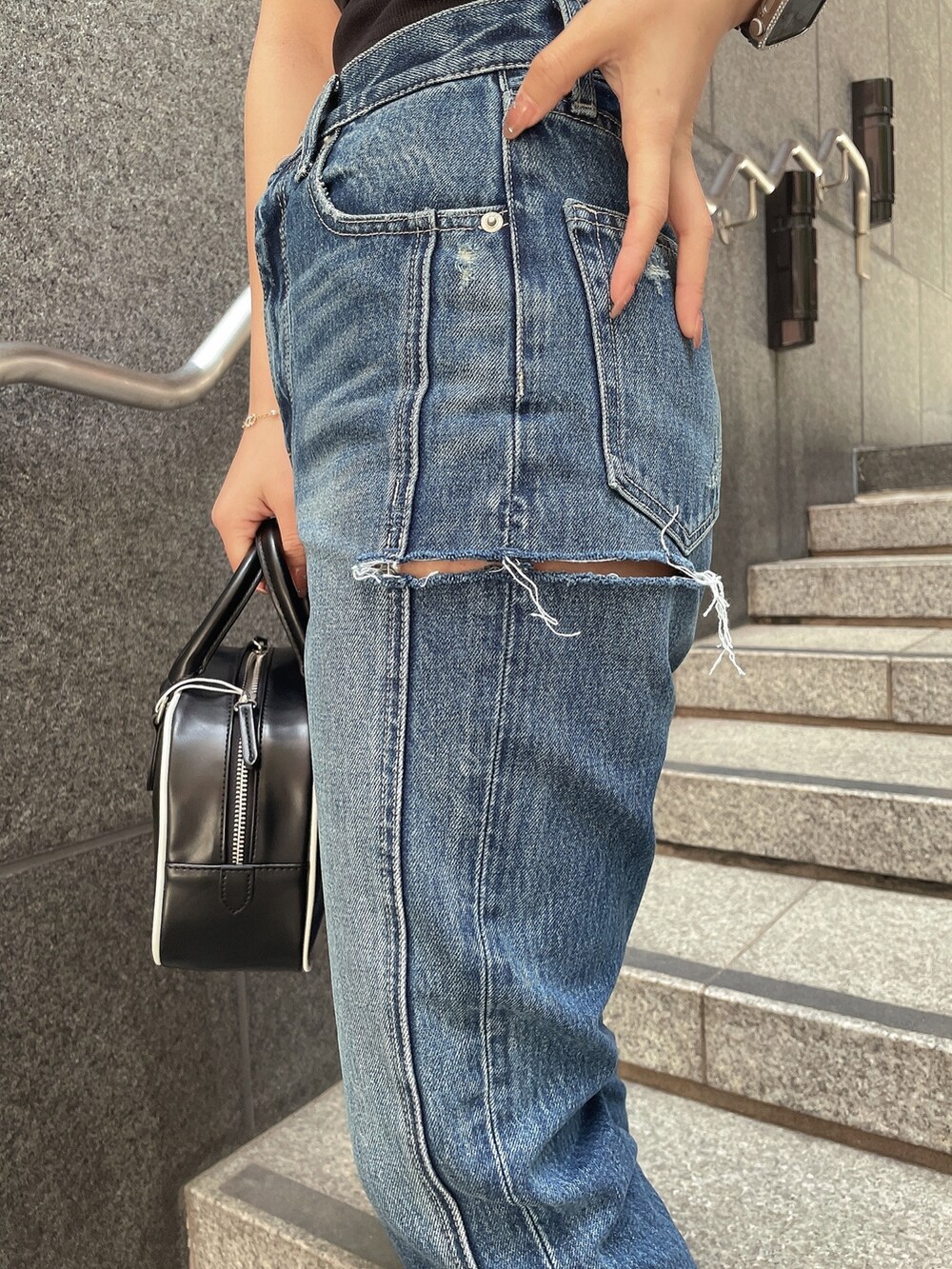 ブラック系のTシャツ/カットソー、ブルー系のデニムパンツ、ブラック系のサンダルを着用したレディースの春コーディネートの7枚目の写真