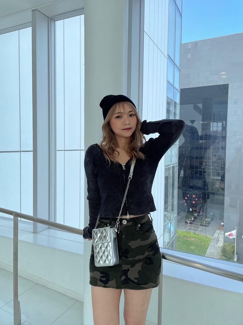 ブラック系のニット/セーター、グリーン系のスカート、ブラック系のブーツを着用したレディースの秋コーディネートの5枚目の写真