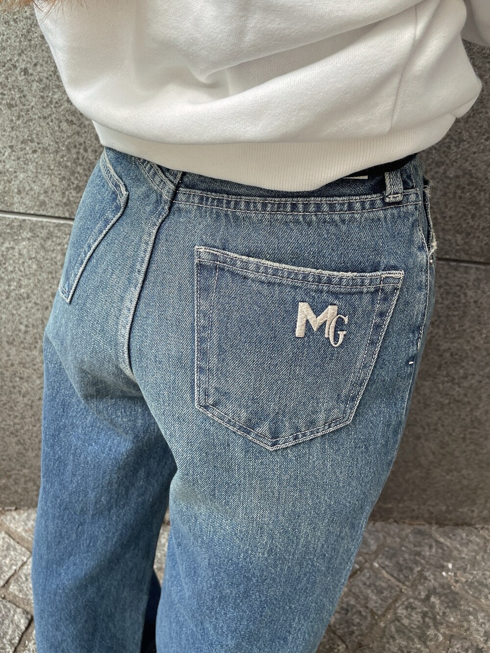 ブラック系のデニムパンツ、ブラック系のブーツ、その他のニット/セーターを着用したレディースの秋コーディネートの9枚目の写真