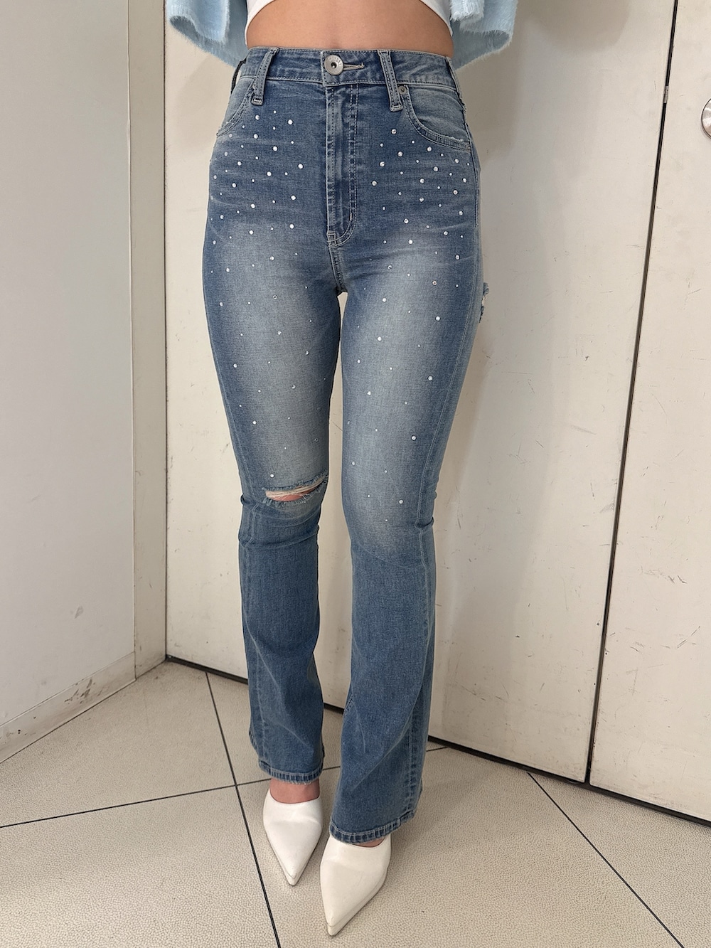 ブルー系のTシャツ/カットソー、ブルー系のデニムパンツ、ホワイト系のパンプスを着用したレディースの冬コーディネートの7枚目の写真