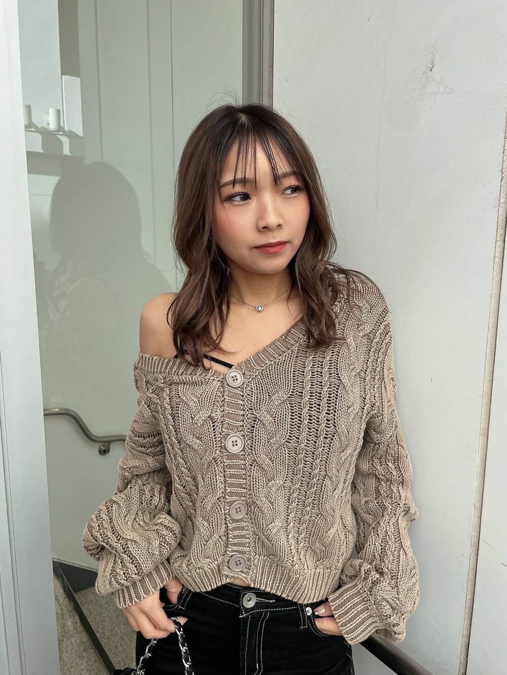 ベージュ系のニット/セーター、ブラック系のキャミソール、ブラック系のデニムパンツを着用したレディースの冬コーディネートの8枚目の写真