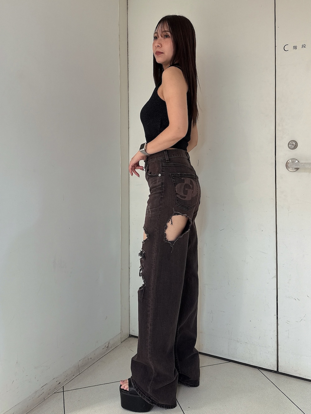 ピンク系のニット/セーター、ブラック系のサンダル、ブラック系のデニムパンツを着用したレディースの夏コーディネートの2枚目の写真