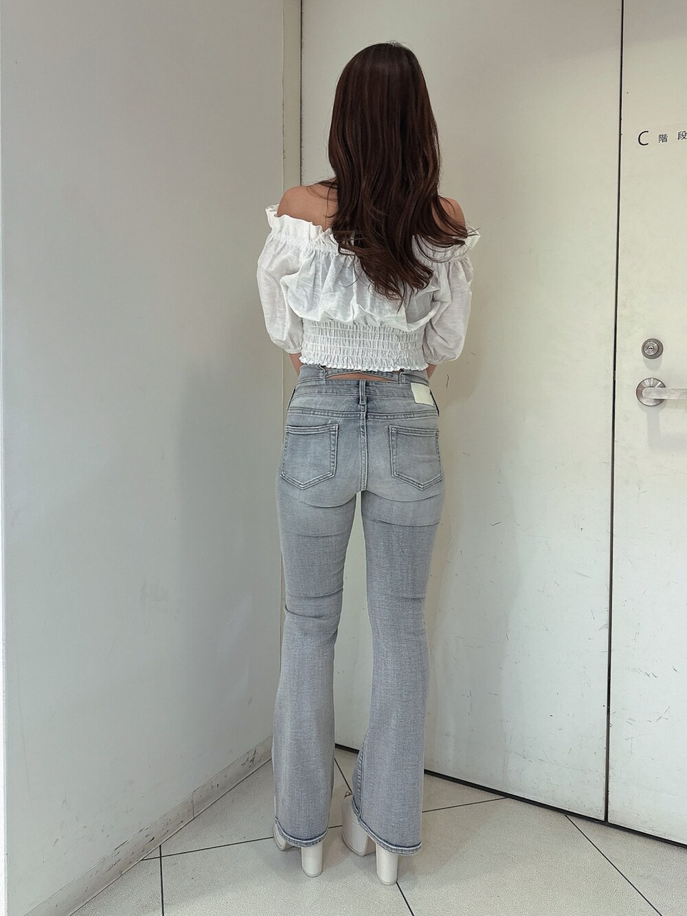 ブルー系のデニムパンツ、ホワイト系のシャツ/ブラウス、ホワイト系のサンダルを着用したレディースの春コーディネートの3枚目の写真