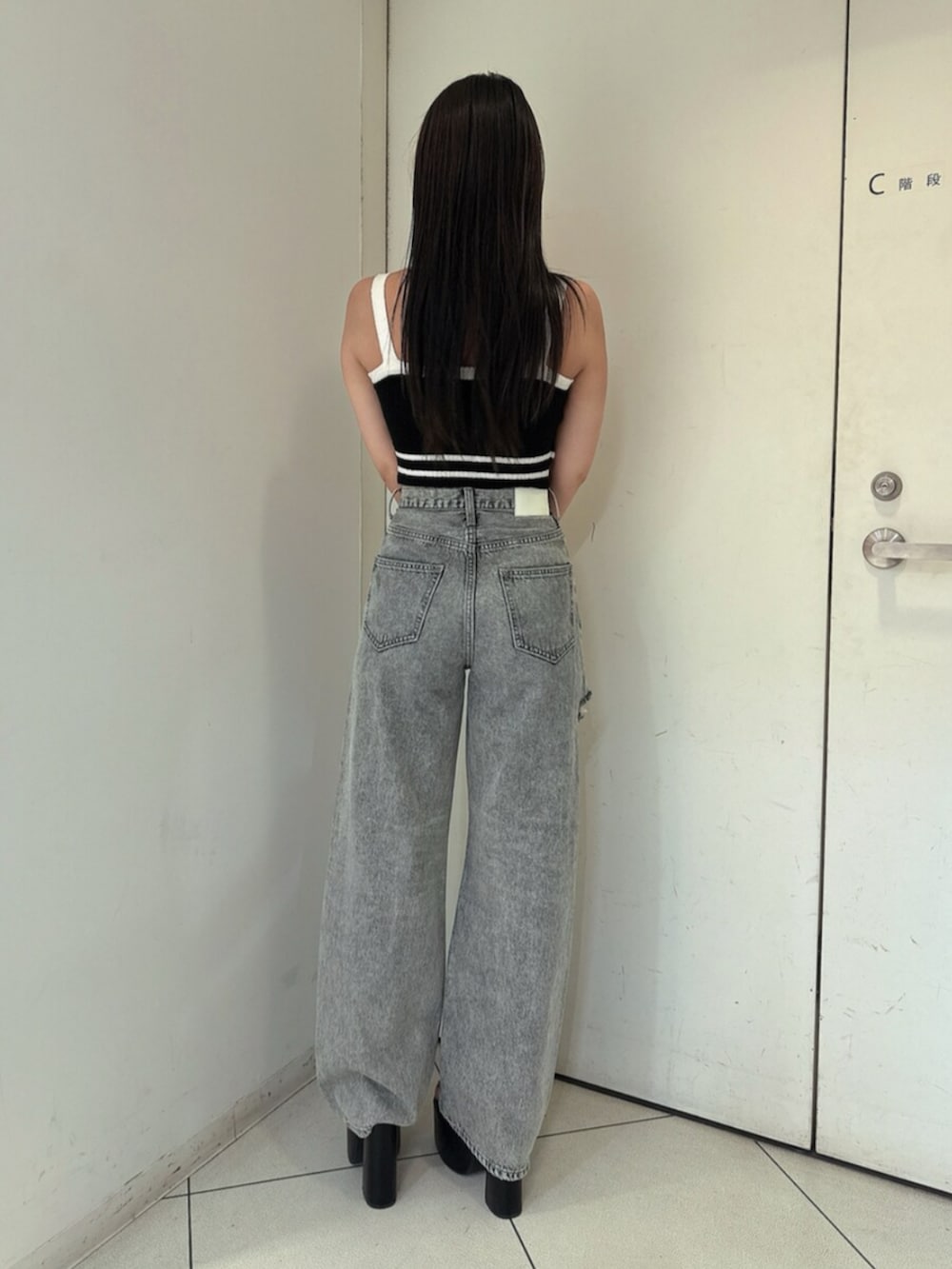 ブラック系のサンダル、ブルー系のデニムパンツ、ブラック系のキャミソールを着用したレディースの春コーディネートの3枚目の写真