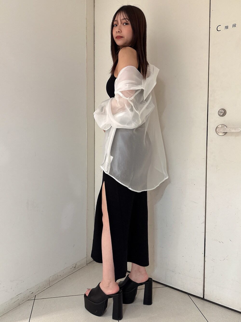 ホワイト系のシャツ/ブラウス、ブラック系のワンピース、ブラック系のサンダルを着用したレディースの夏コーディネートの2枚目の写真