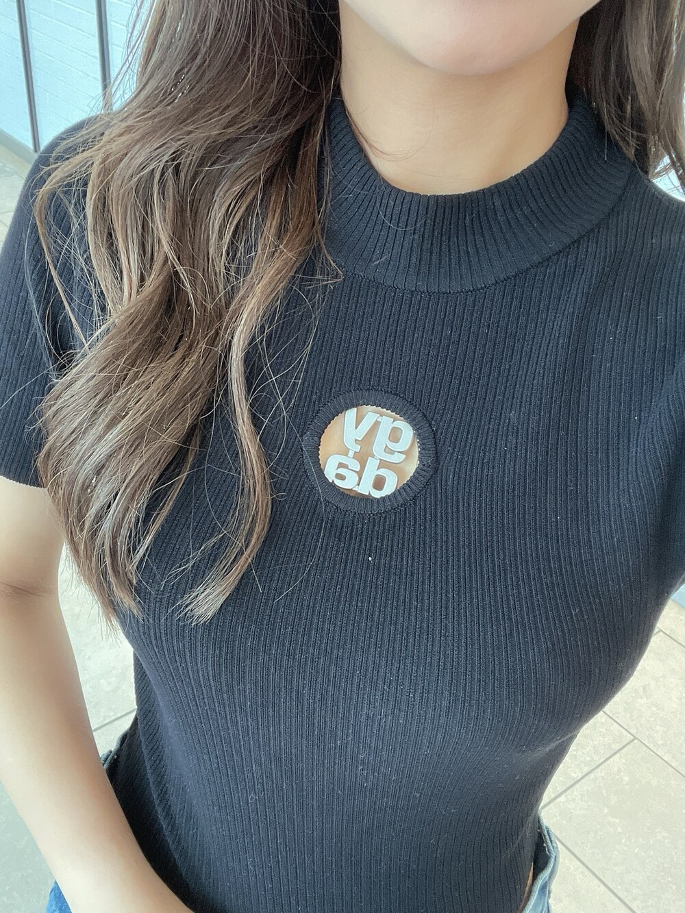 ブラック系のニット/セーター、ブラック系のサンダル、ブルー系のデニムパンツを着用したレディースの夏コーディネートの9枚目の写真