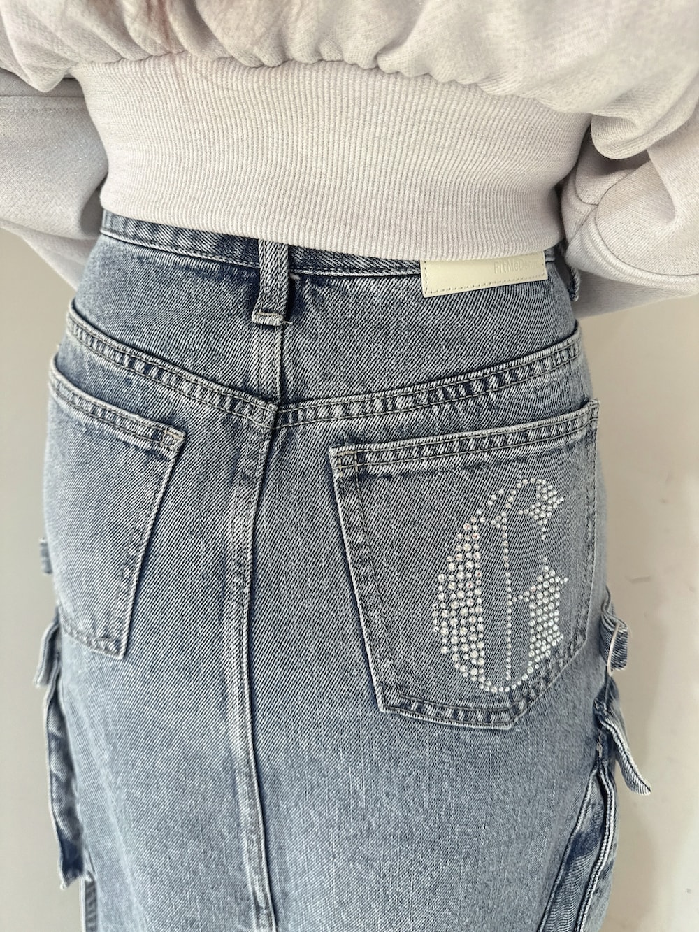 ブルー系のデニムスカート、ホワイト系のTシャツ/カットソー、ブラック系のブーツを着用したレディースの冬コーディネートの9枚目の写真