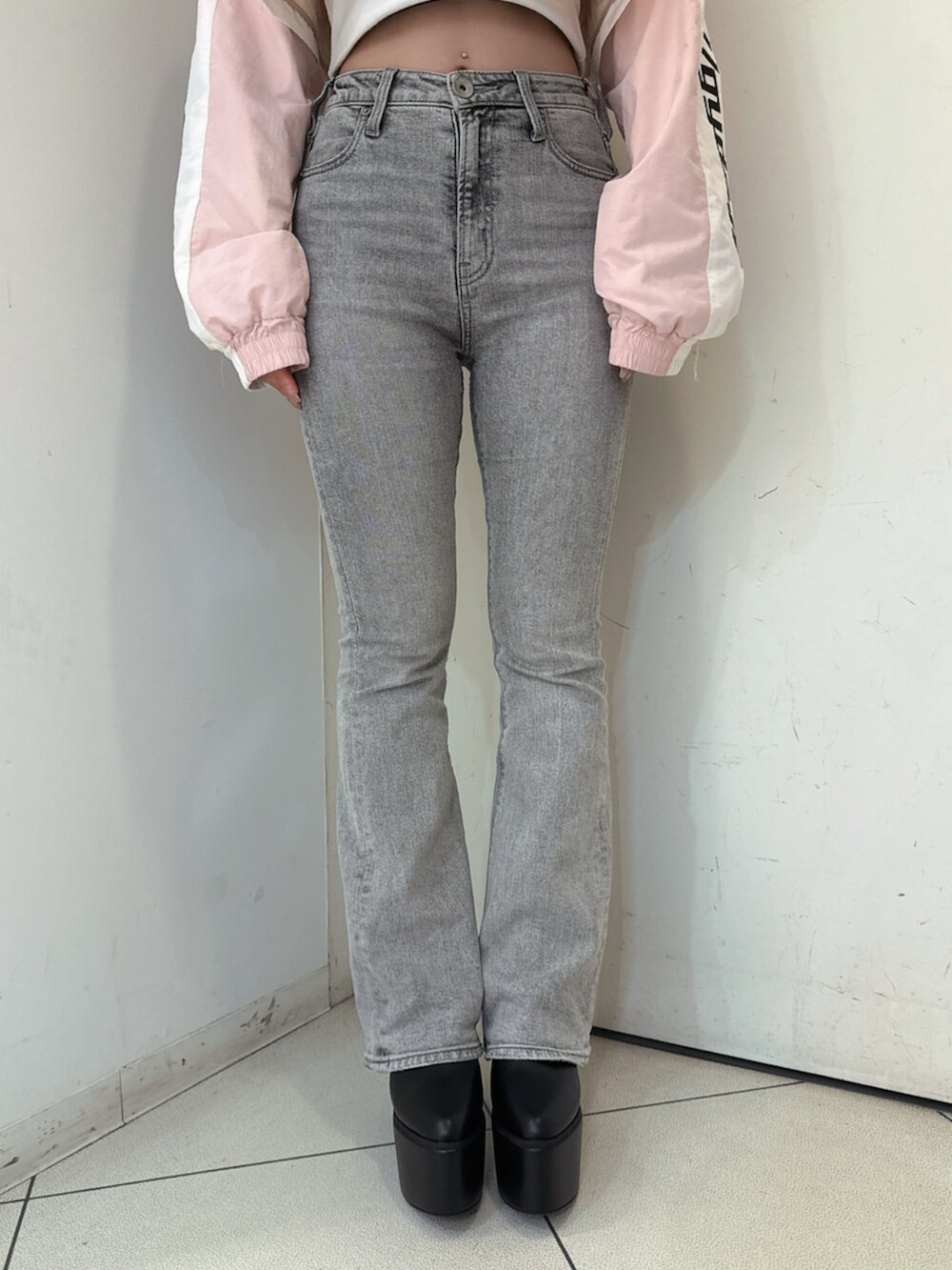 グレー系のデニムパンツ、ホワイト系のTシャツ/カットソー、ブラック系のブーツを着用したレディースの夏コーディネートの8枚目の写真