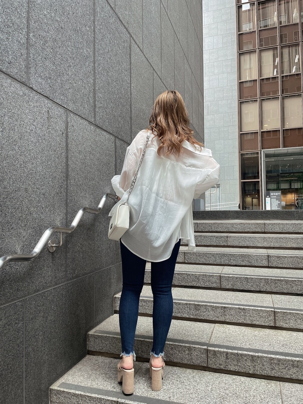 ホワイト系のシャツ/ブラウス、ホワイト系のチューブトップ、ブルー系のデニムパンツを着用したレディースの夏コーディネートの2枚目の写真