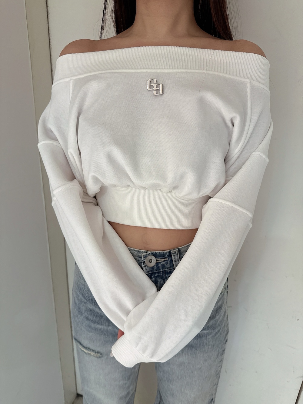 ホワイト系のスウェット、ブルー系のデニムパンツ、ホワイト系のサンダルを着用したレディースの冬コーディネートの7枚目の写真