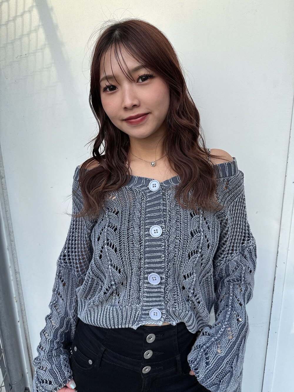 ブルー系のニット/セーター、ブラック系のデニムパンツ、ホワイト系のパンプスを着用したレディースの春コーディネートの4枚目の写真