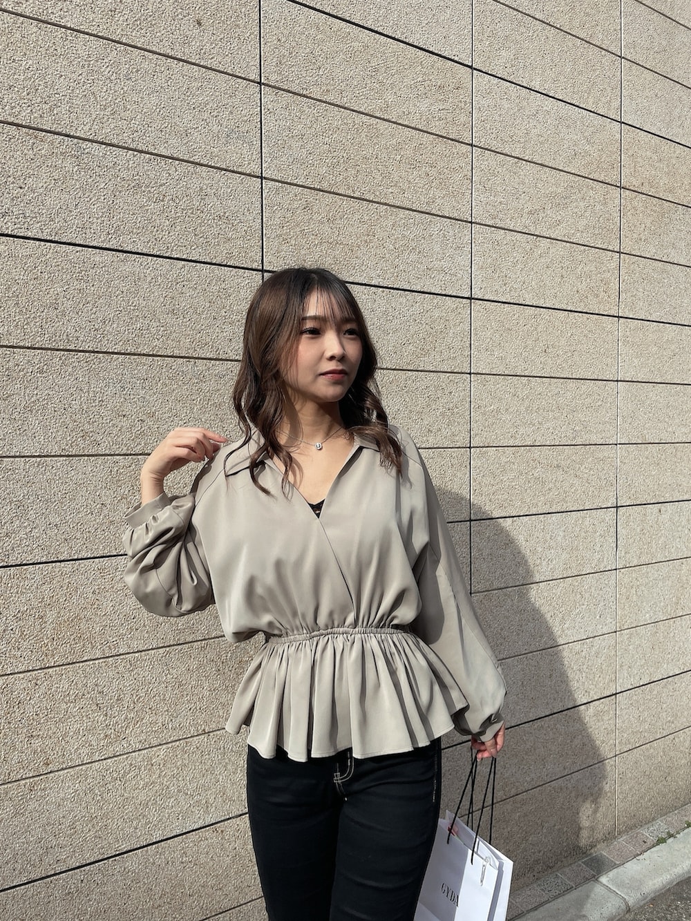 ベージュ系のシャツ/ブラウス、ブラック系のキャミソール、ブラック系のデニムパンツを着用したレディースの冬コーディネートの3枚目の写真