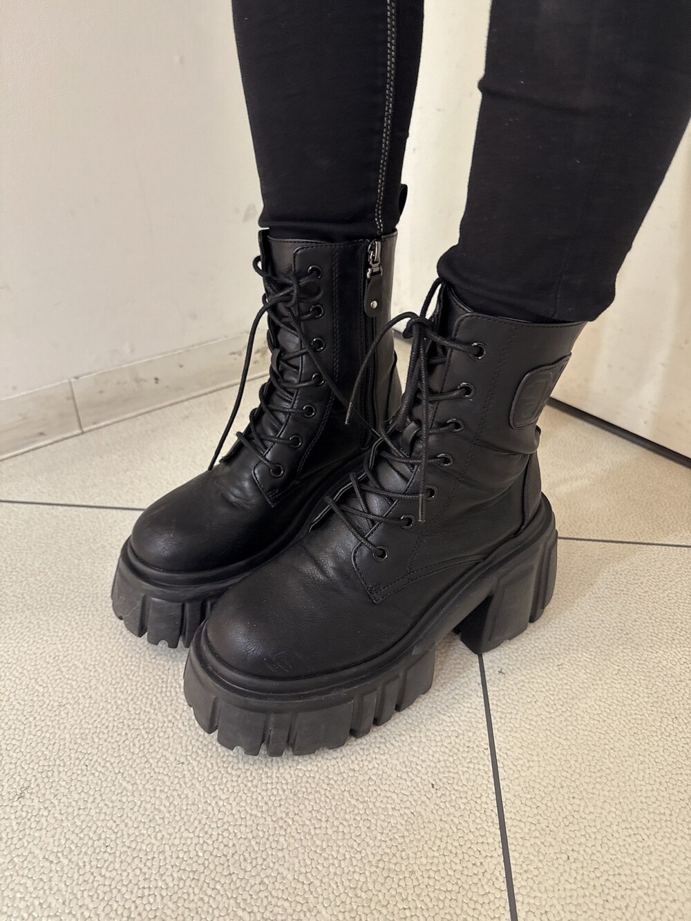 ホワイト系のニット/セーター、ブラック系のデニムパンツ、ブラック系のブーツを着用したレディースの秋コーディネートの9枚目の写真