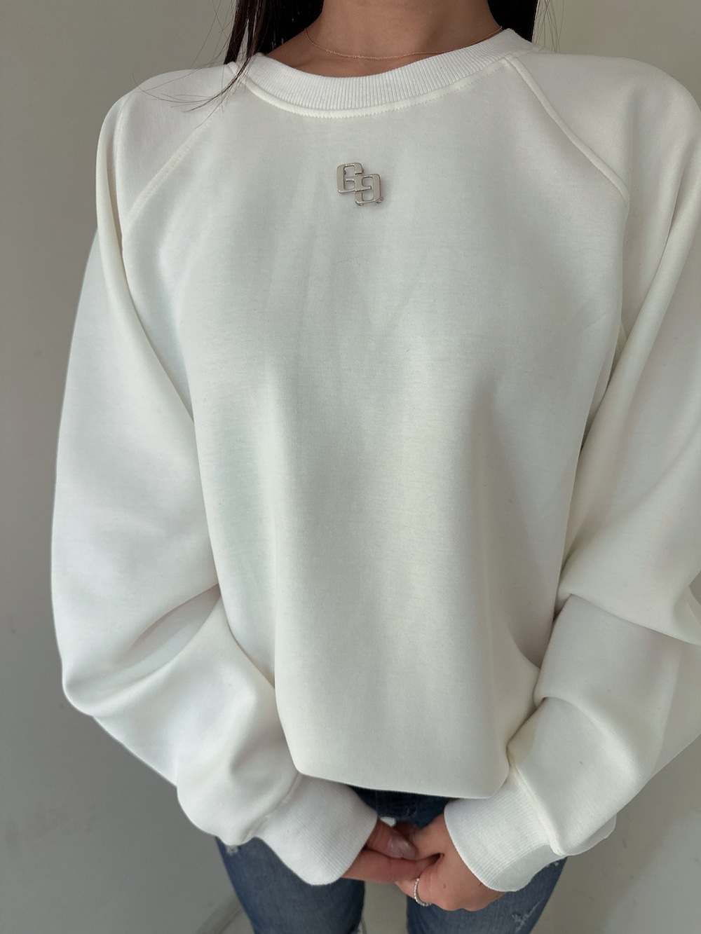 ブルー系のデニムパンツ、ブラック系のブーツ、ホワイト系のスウェットを着用したレディースの冬コーディネートの8枚目の写真