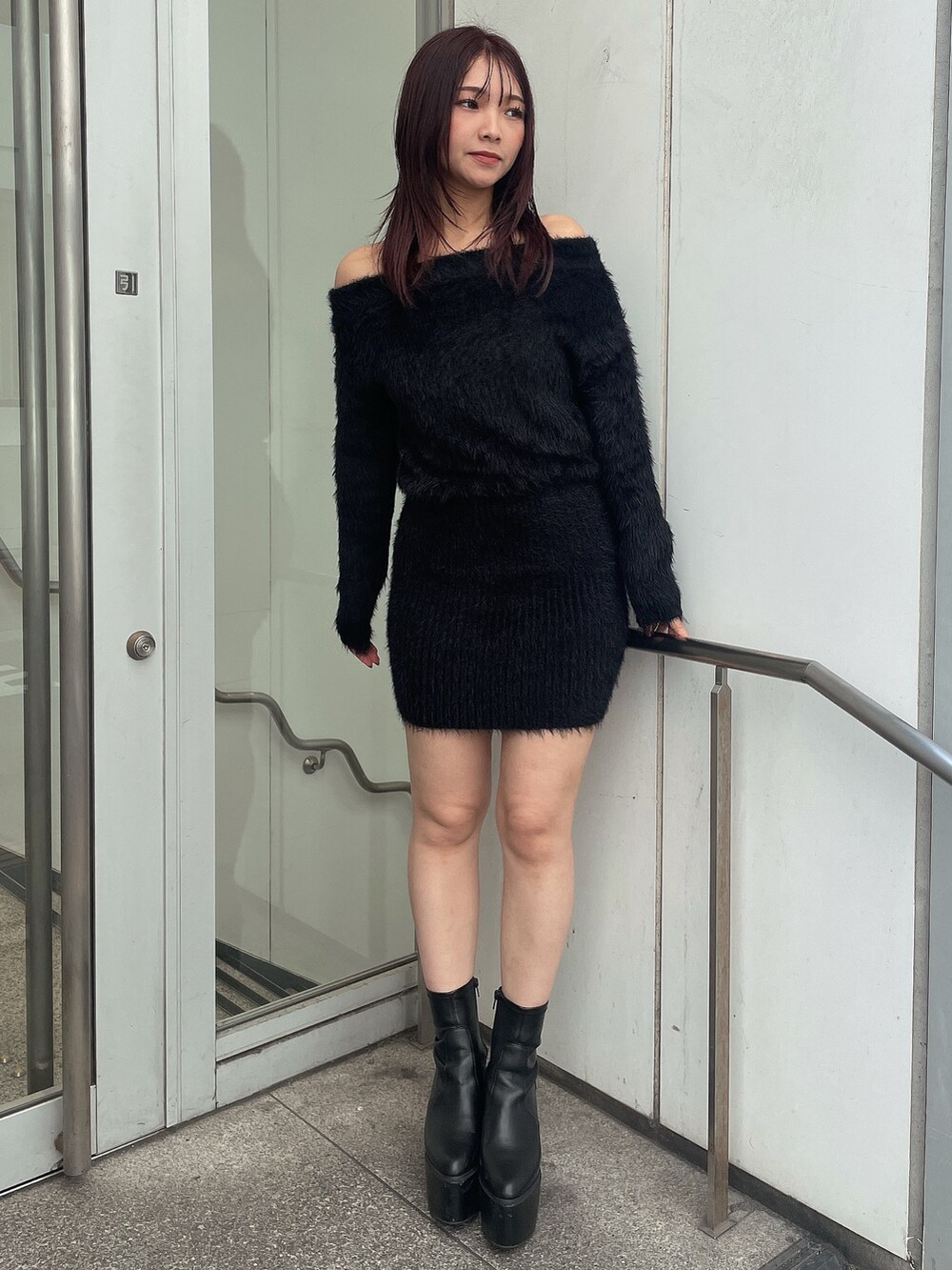 ブラック系のブーツ、ブラック系のワンピース、グレー系のライダースジャケットを着用したレディースの秋コーディネートの5枚目の写真