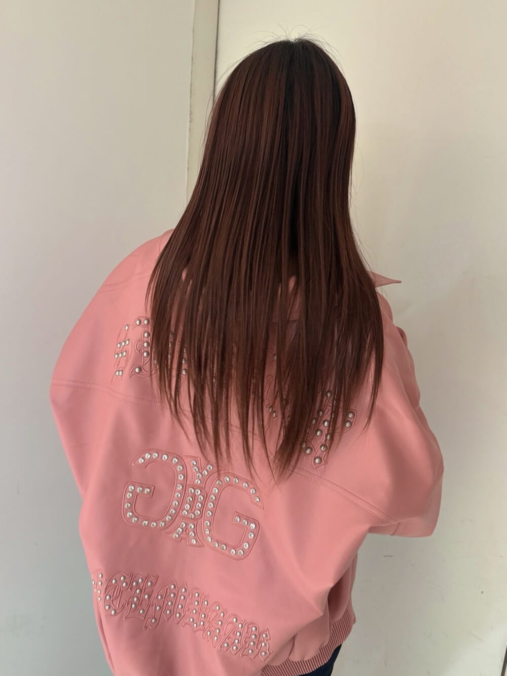 ブルー系のデニムパンツ、ブラック系のサンダル、ピンク系のブルゾンを着用したレディースの春コーディネートの6枚目の写真