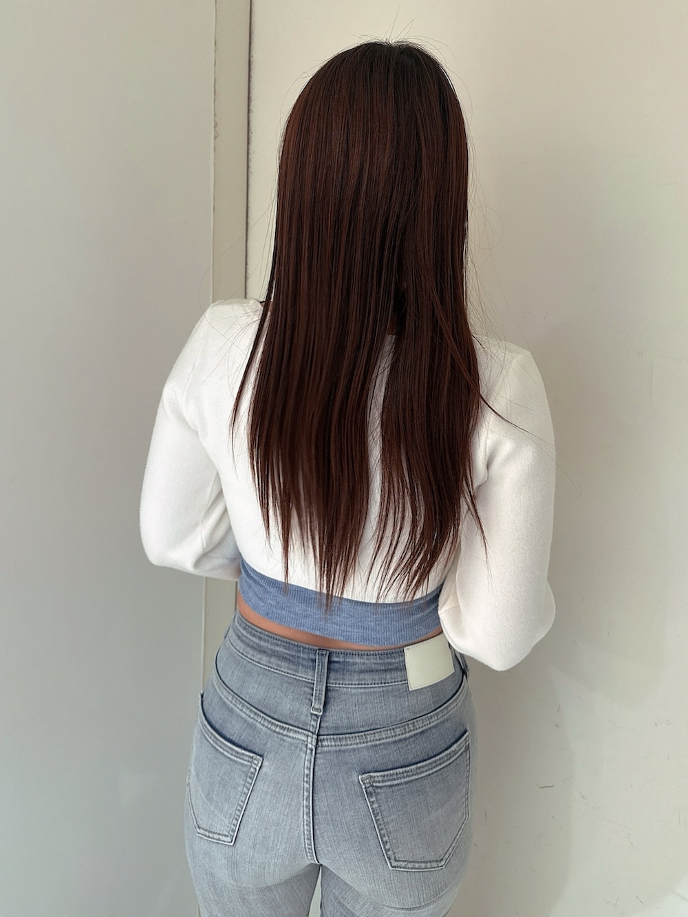 ブルー系のデニムパンツ、ブラック系のサンダル、ホワイト系のカーディガン/ボレロを着用したレディースの春コーディネートの6枚目の写真