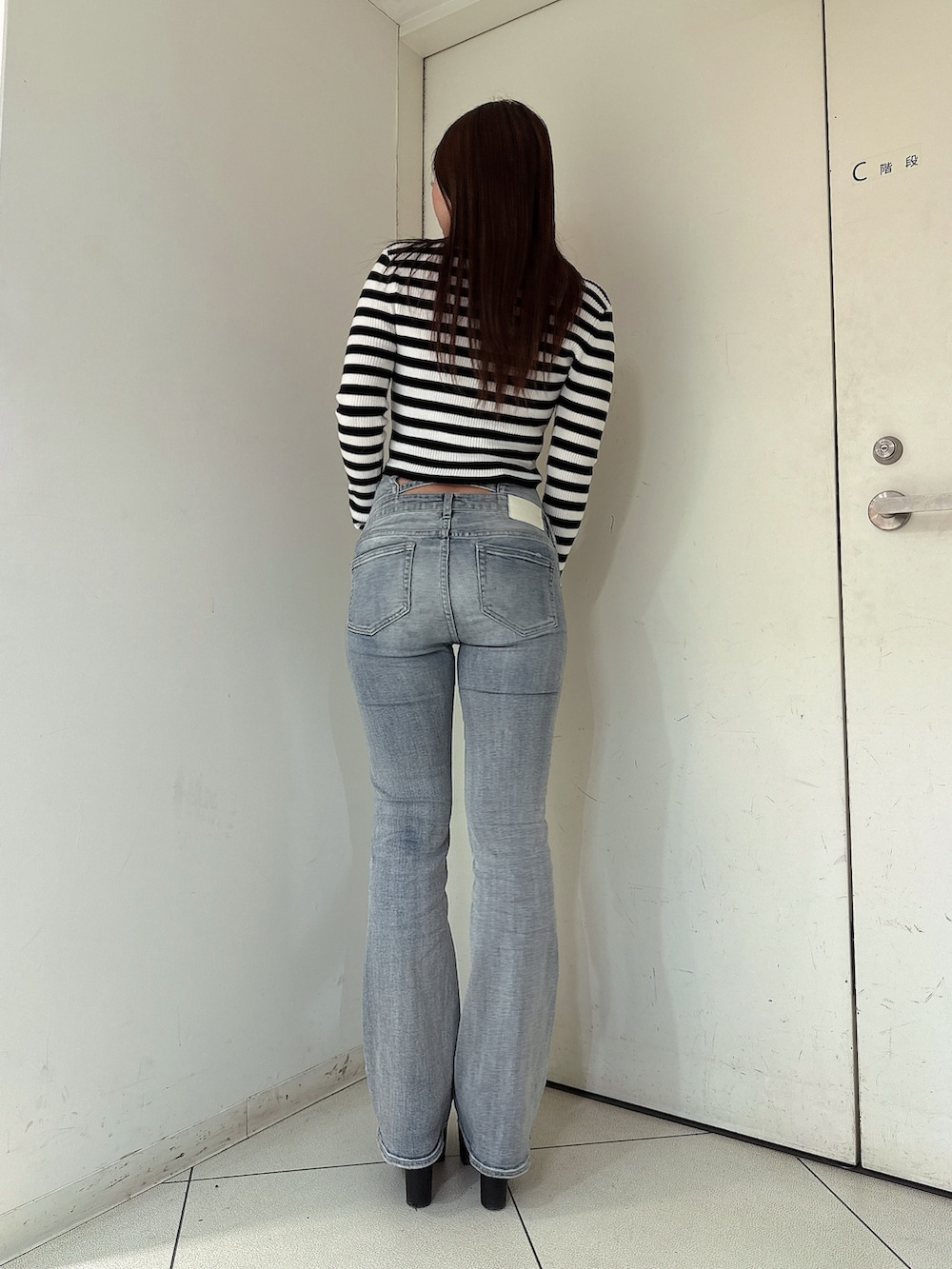 ブルー系のデニムパンツ、ブラック系のブーツ、その他のニット/セーターを着用したレディースの冬コーディネートの3枚目の写真