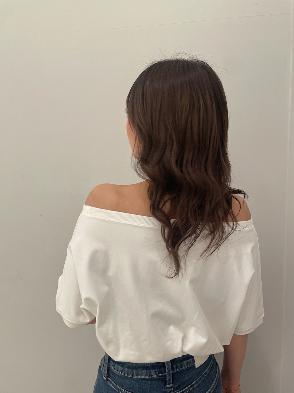 ホワイト系のTシャツ/カットソー、ブルー系のデニムパンツ、ブラック系のバックパック/リュックを着用したレディースの春コーディネートの6枚目の写真