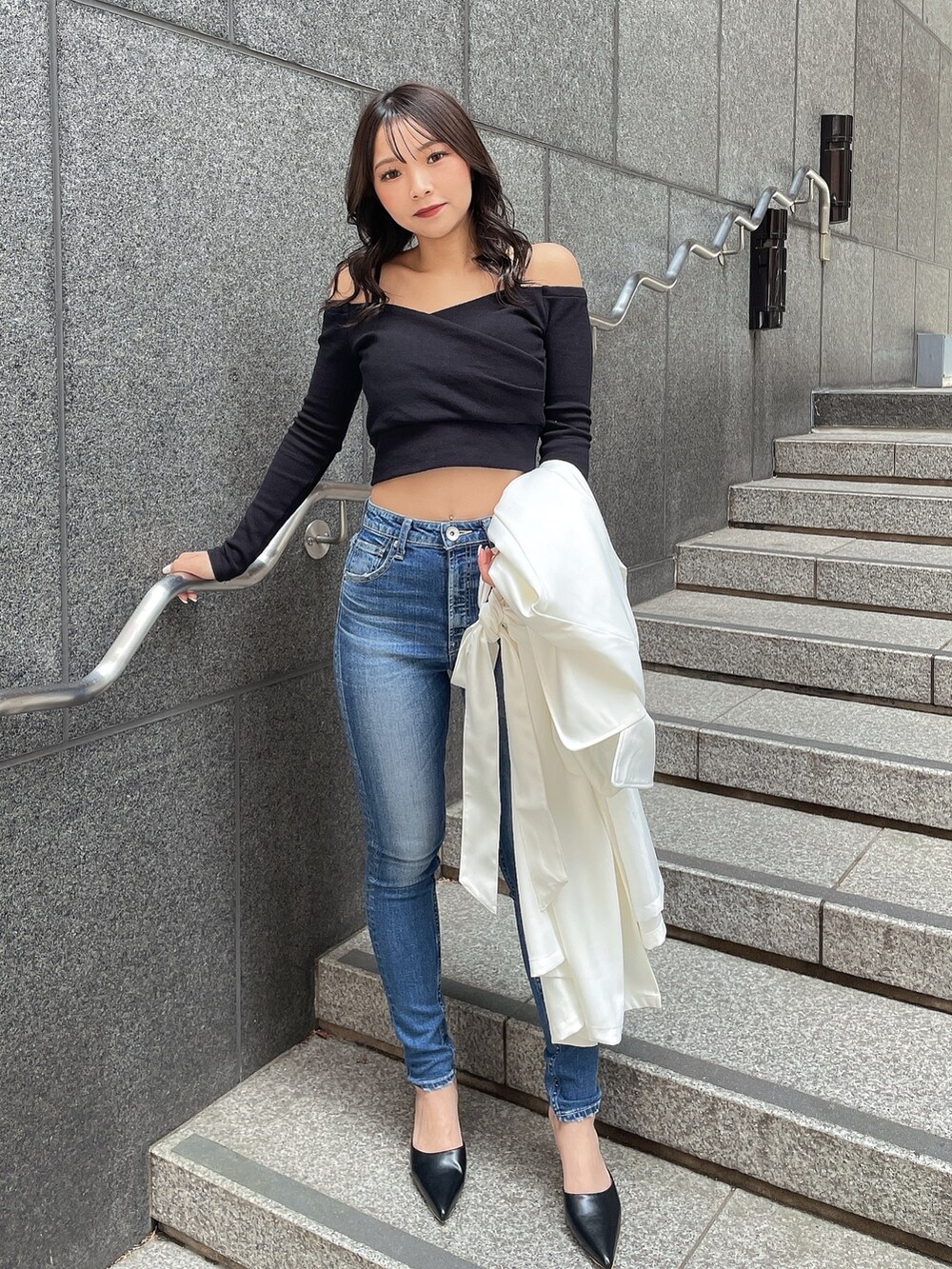 ホワイト系のトレンチコート、ブラック系のTシャツ/カットソー、ブルー系のデニムパンツを着用したレディースの春コーディネートの5枚目の写真