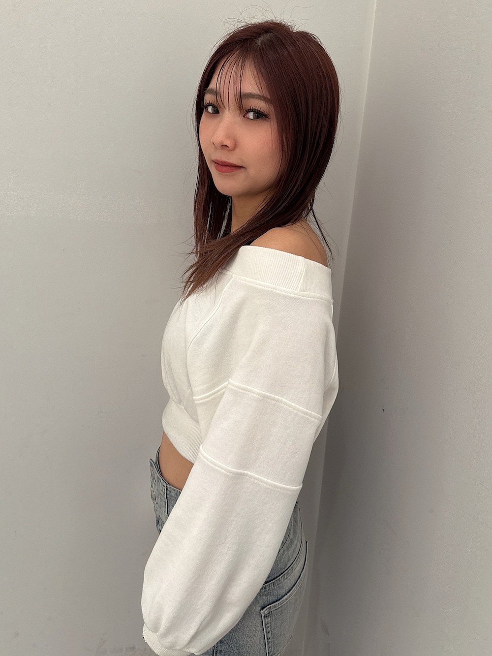 ブルー系のデニムパンツ、ホワイト系のパンプス、ホワイト系のスウェットを着用したレディースの冬コーディネートの5枚目の写真