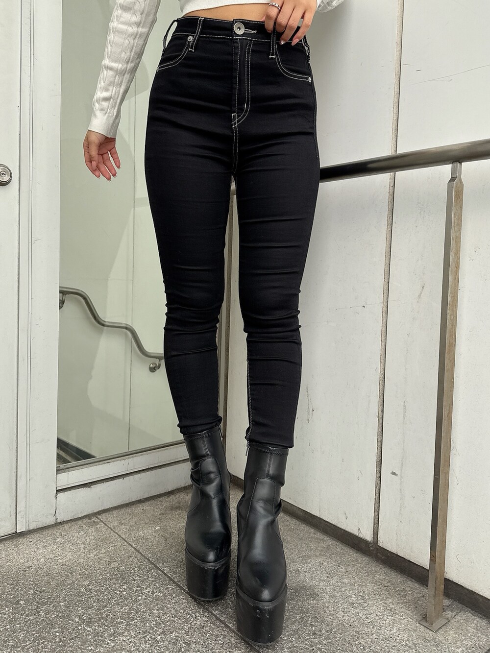 グレー系のブルゾン、ブラック系のデニムパンツ、ブラック系のブーツを着用したレディースの冬コーディネートの8枚目の写真